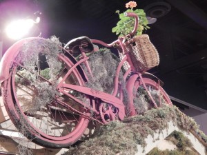 Vintage bike being used as a planter, on a garden shed roof