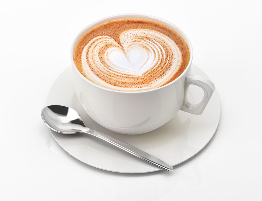 Cappuccino mug close up, with a heart decorated on top of foam. On white background with clipping path.